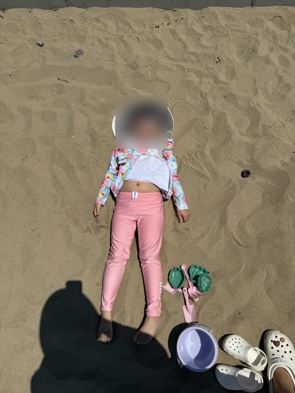 모래 위에 누워 쉬는 6세 딸