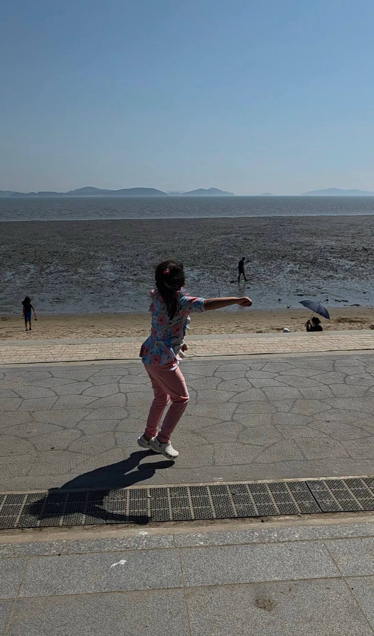 해변 산책로에서 뛰노는 딸