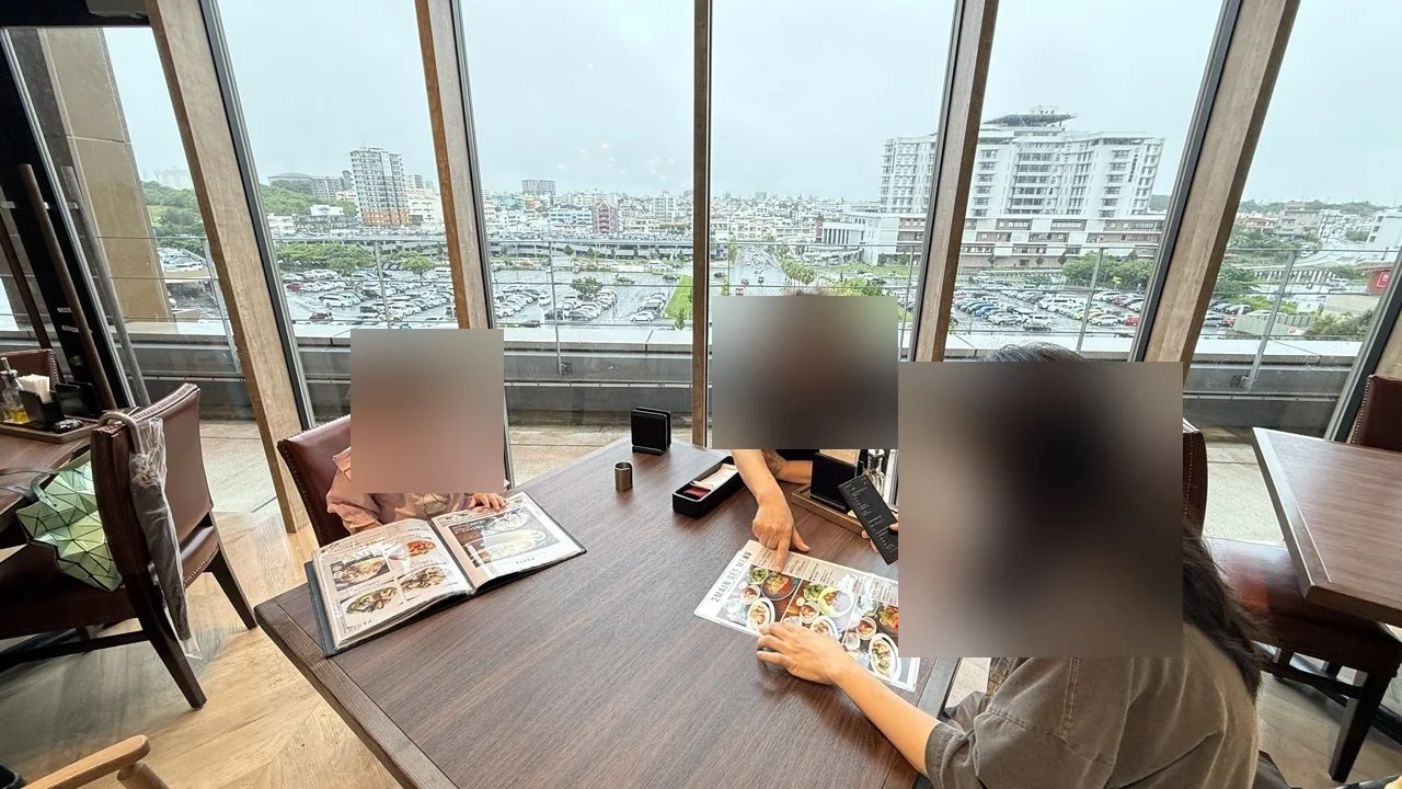 창가 테이블에서 메뉴판을 보는 가족과 비 오는 창밖 풍경