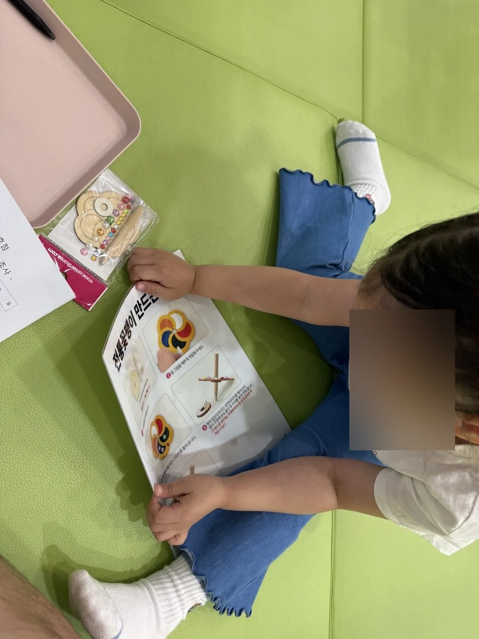 시립1호점 만들기 체험에서 바람개비 설명서를 보는 아이