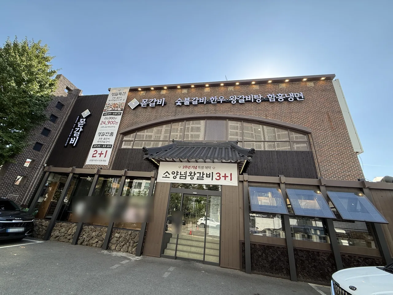 숯불갈비와 함흥냉면 간판이 걸린 몯갈비 건물과 가게 앞 주차 공간, 평일특선 현수막
