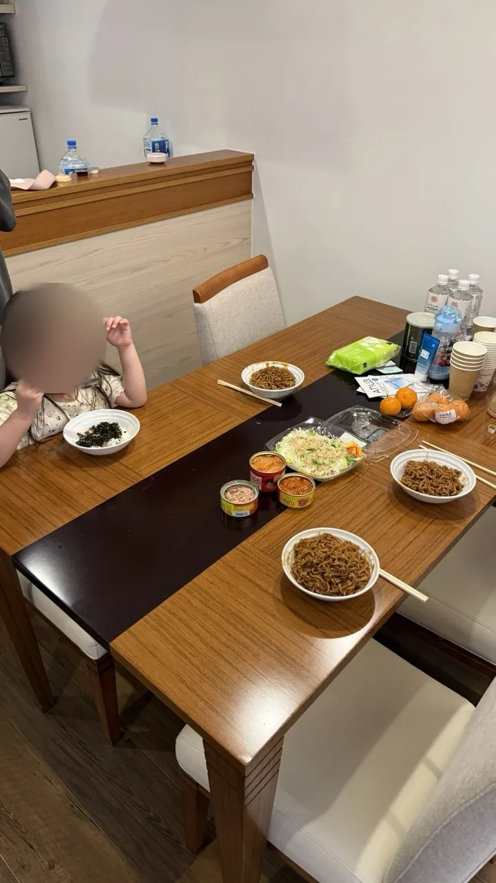 객실 식탁 위에 차려진 짜장라면과 샐러드와 귤