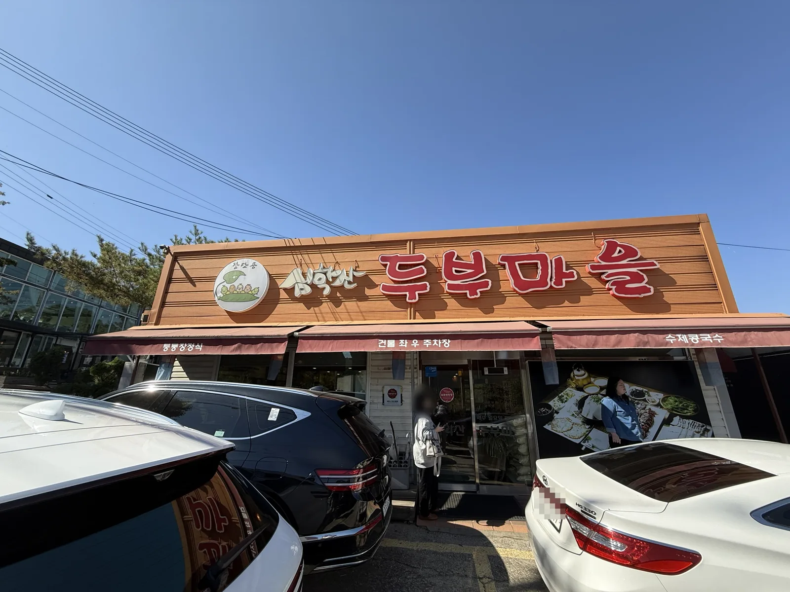파주 심학산 두부마을 외관과 건물 앞 주차 공간, 번호판은 가림