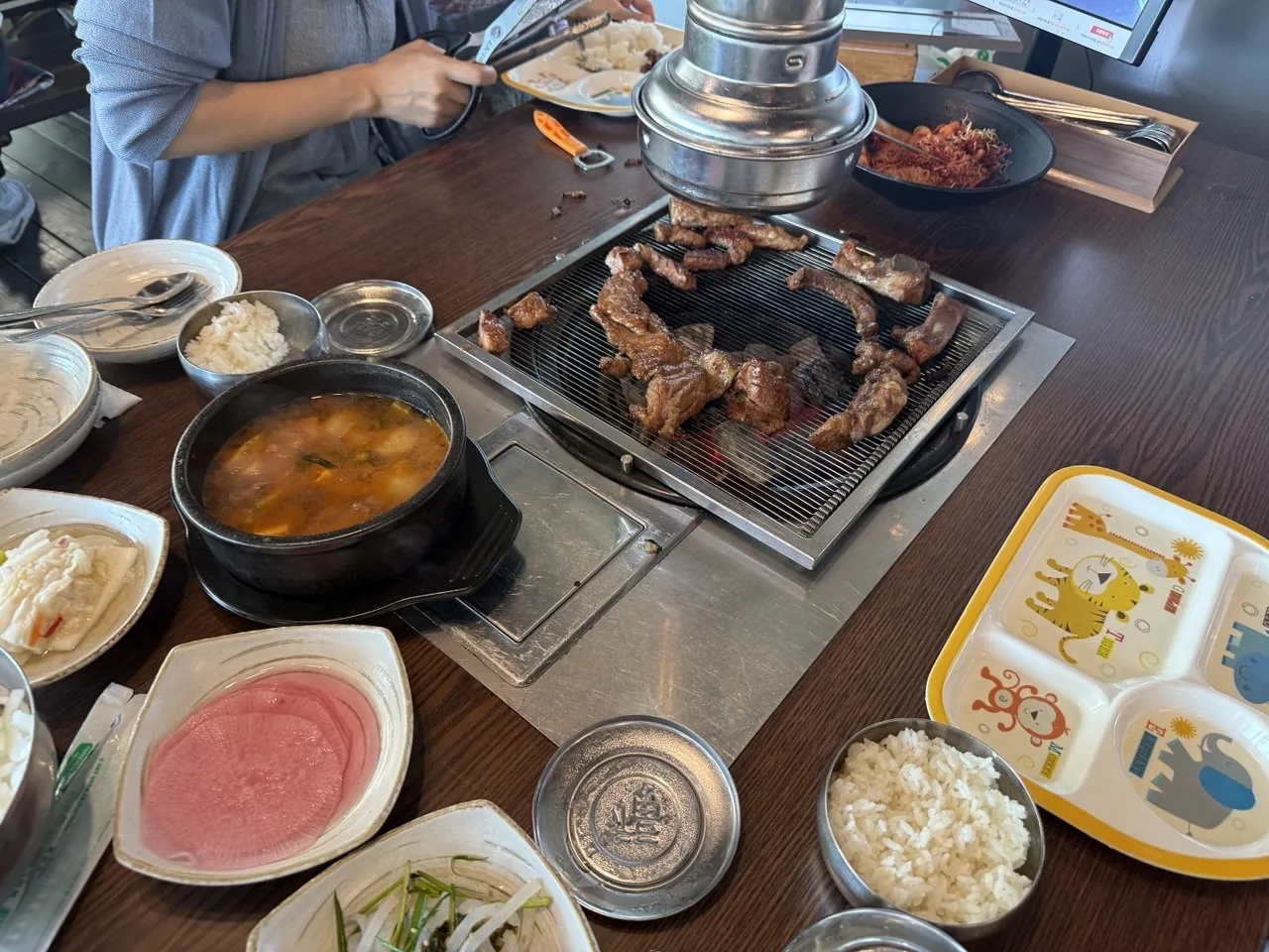 숯불 갈비와 된장찌개, 아이 식판이 차려진 식탁